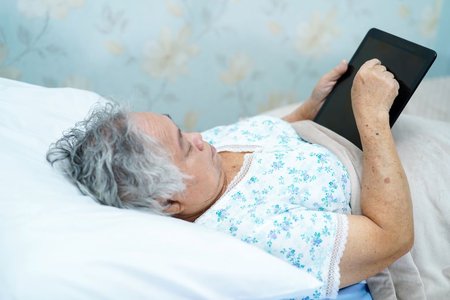 Tablets und digitale Medien bieten vielfältige Möglichkeiten für den Zeitvertreib im Pflegebett.