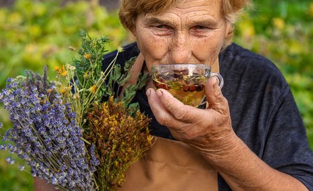 „Für jedes Wehwehchen hilft ein Teechen“ – Heilkräuter wirken vielfältig. Die Einnahme als Tee gilt dabei als besonders bekömmlich. Seniorin trinkt einen Kräutertee